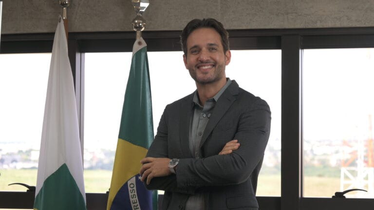 Executivo sorridente durante entrevista para vídeo institucional, gravado em escritório corporativo pela Vértice Audiovisual